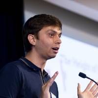 Scholar presenting research at podium.